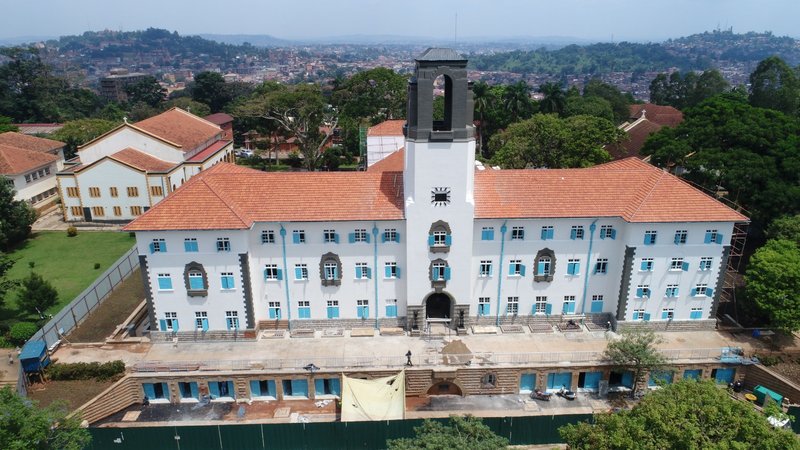 An elevated front view of the sunlit reconstructed Main Building nearing completion.