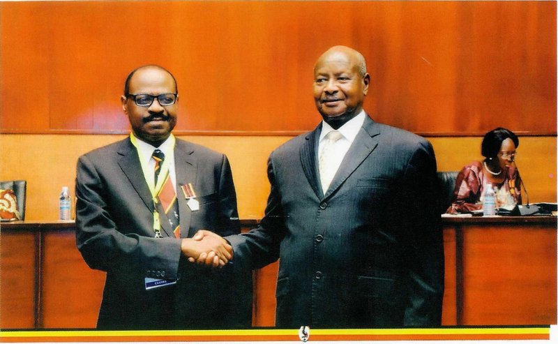 H.E. Yoweri Museveni (R) shakes hands with Prof. Khiddu Makubuya after awarding Golden Jubilee Medals to all memebers of the 1st-9th Parliament in 2016.