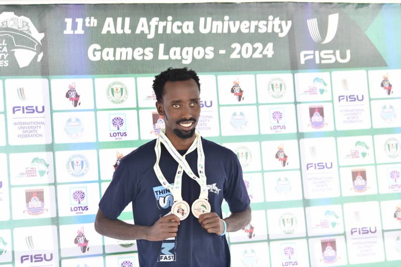 Jacob Mugisha displaying some of his medals from one of the swimming events