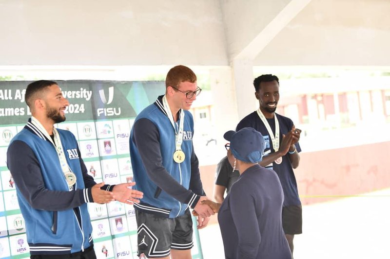 Jacob Mugisha receives his medal from the Tri-level podium along with athletes from other African universities